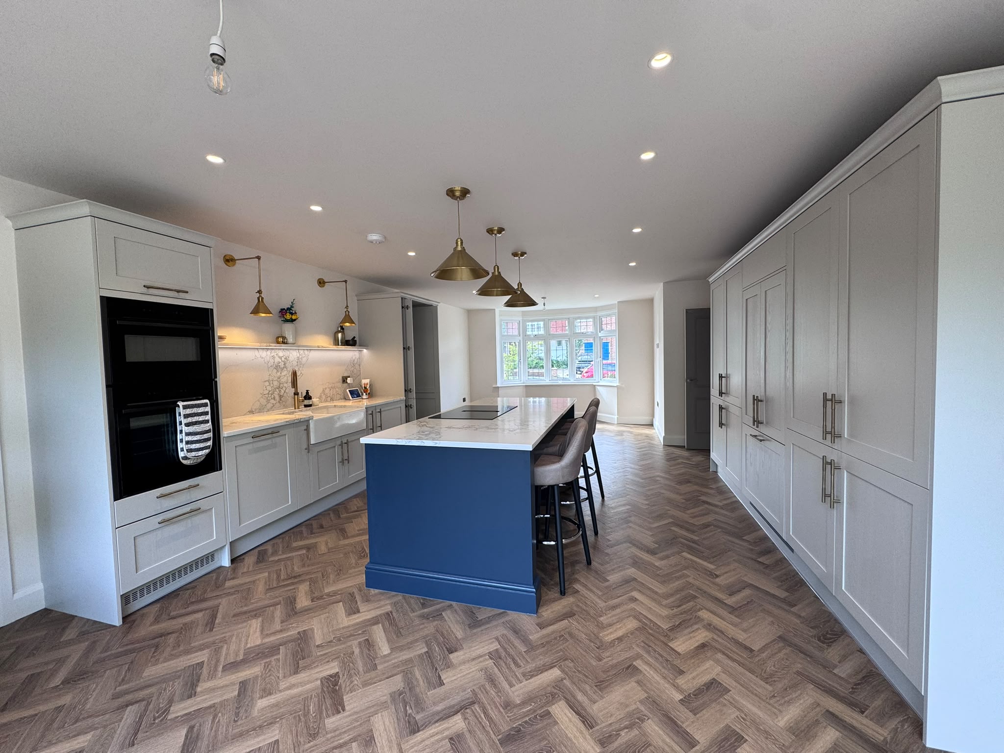 LVT flooring in Epsom kitchen with blue island and light cabinetry
